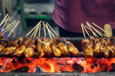 Tipik Endonezya sokak yemekleri tavuk satay, tavuk eti bambu çubuğuna eğilmiş kömürle kızartılmış ve tatlı fıstık sosuyla servis edilmiş..