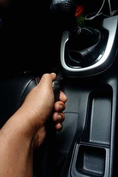 Hand pulling the hand break Handle on manual car