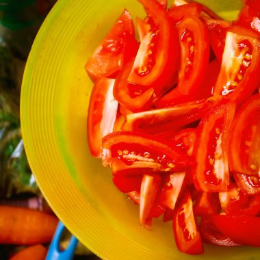 Close up picture of sliced tomatoes in a yellow plastic plate