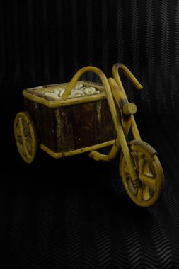 Siyah arka planda izole edilmiş ahşaptan yapılmış tahta bisiklet oyuncağı. 