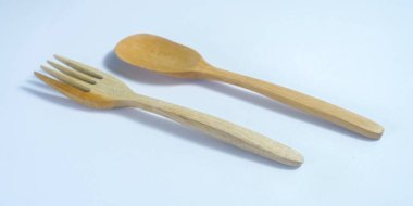 Tahta kaşık ve ahşap çatal beyaz arka plandaki stüdyoda izole edilmiş. Gündüz çekim yap, uzay taklidi yap. 