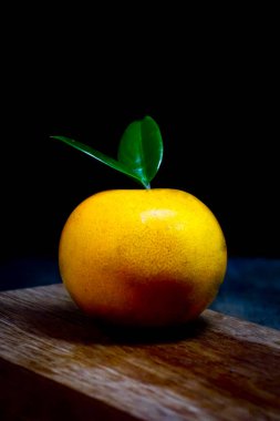 Ahşap masada koyu renkli portakal meyvesi. 