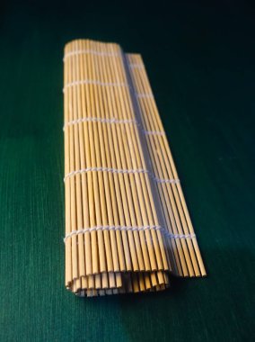 Yeşil arka planda izole edilmiş bambudan yapılmış suşi makinesi araçları 