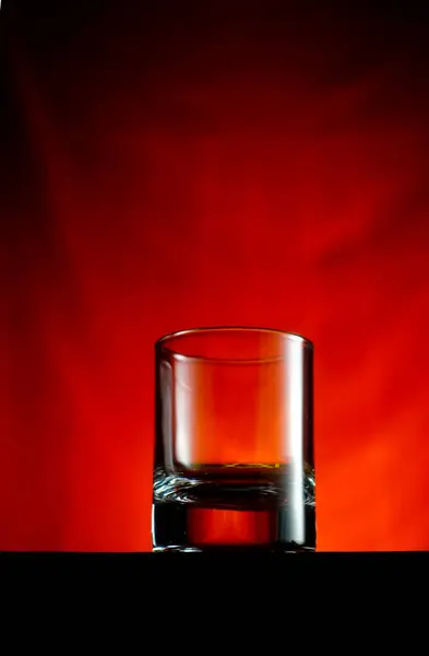 Пустой Стакан Виски Деревянном Столе Красным Фоном — стоковое фото