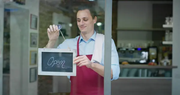 Mann Eröffnet Café Für Kunden lizenzfreie Stockfotos