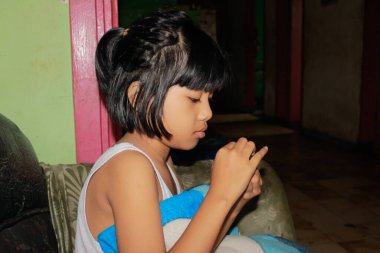 Küçük kız kanepede hayal kuruyor.