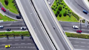 Beautiful aerial view to the cars driving on multi-level highway in Izmir. Direct view from above to the road traffic in a big city on the sunny evening. High quality FullHD footage