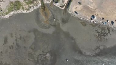 Aerial view of beautiful beach and stranded boats with pattern of sands after receding water level due to tide in aegean sea