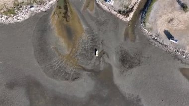 Güzel sahil manzarası ve kumlu tekneler Ege Denizi 'ndeki gelgitten dolayı su seviyesi düştükten sonra karaya oturdu.