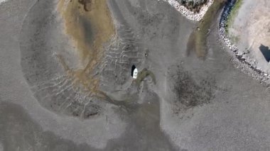 Aerial view of beautiful beach and stranded boats with pattern of sands after receding water level due to tide in aegean sea
