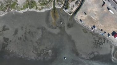 Aerial view of beautiful beach and stranded boats with pattern of sands after receding water level due to tide in aegean sea