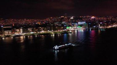 Ege Denizi 'nde ilerleyen feribotun hava görüntüsü İzmir' deki kentin gece görüşü ile birlikte. Yüksek kaliteli FullHD görüntüler