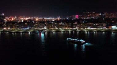 Ege Denizi 'nde ilerleyen feribotun hava görüntüsü İzmir' deki kentin gece görüşü ile birlikte. Yüksek kaliteli FullHD görüntüler