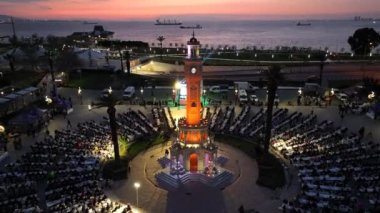Ramazan ayında, tarihi saat kulesinin altında birlikte dua eden ve oruç tutan insanların hava görüntüsü. Yüksek kalite 4k görüntü