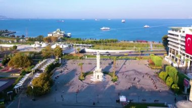 Trafiğin hava görüntüsü, tramvay durağı ve tarihi saat kulesinden denize giden feribotlar., 