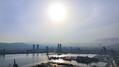 İzmir 'de sisli bir sabahta liman, gümrük ve gökdelenler manzaralı gün doğumu. Yüksek kalite 4k görüntü