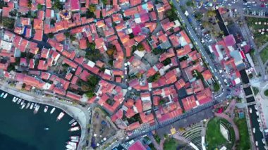 Tuhaf Ege kasabası Sicacik 'in havadan görünüşü, tarihi şatosu ve evleri, balıkçılık limanı ve deniz. Yüksek kaliteli FullHD görüntüler