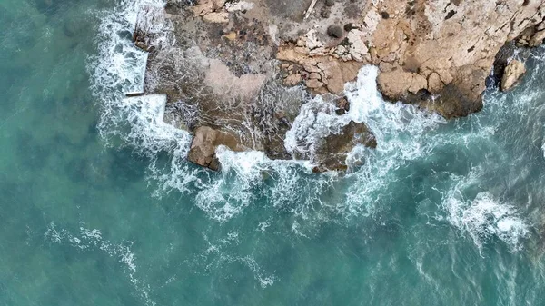 用无人驾驶飞机拍摄海浪撞击岩石的空中图像 免版税图库照片