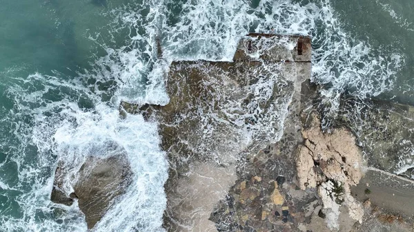 用无人驾驶飞机拍摄海浪撞击岩石的空中图像 图库照片