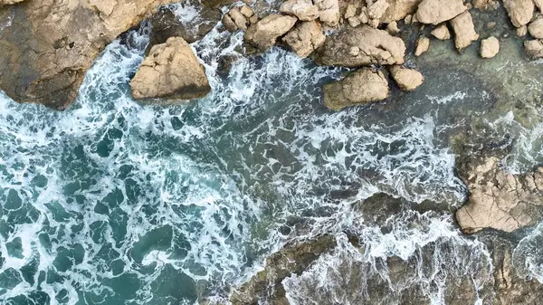 用无人驾驶飞机拍摄海浪撞击岩石的空中图像 免版税图库照片