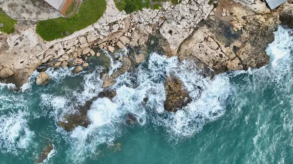 用无人驾驶飞机拍摄海浪撞击岩石的空中图像 图库图片