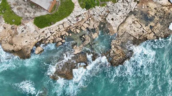 用无人驾驶飞机拍摄海浪撞击岩石的空中图像 图库图片