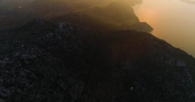 Gün doğumunda dağların üzerinde deniz ve güneş doğar. Yüksek kalite 4k görüntü