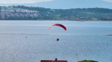 İHA 'yla denizin üzerinde uçan bir Paramotor' un hava takibi. Yüksek kalite 4k görüntü