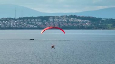 İHA 'yla denizin üzerinde uçan bir Paramotor' un hava takibi. Yüksek kalite 4k görüntü