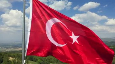 Türk Bayrağı sallıyor. Bulutlu bir günde Türk Bayrağı 'nın insansız hava aracıyla yüksek kaliteli görüntüsü. Yüksek kaliteli FullHD görüntüler