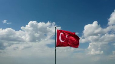 Türk Bayrağı sallıyor. Bulutlu bir günde Türk Bayrağı 'nın insansız hava aracıyla yüksek kaliteli görüntüsü. Yüksek kaliteli FullHD görüntüler