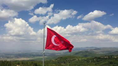Türk Bayrağı sallıyor. Bulutlu bir günde Türk Bayrağı 'nın insansız hava aracıyla yüksek kaliteli görüntüsü. Yüksek kaliteli FullHD görüntüler