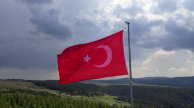 Türk Bayrağı sallıyor. Bulutlu bir günde Türk Bayrağı 'nın insansız hava aracıyla yüksek kaliteli görüntüsü. Yüksek kaliteli FullHD görüntüler