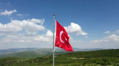 Türk Bayrağı sallıyor. Bulutlu bir günde Türk Bayrağı 'nın insansız hava aracıyla yüksek kaliteli görüntüsü. Yüksek kaliteli FullHD görüntüler