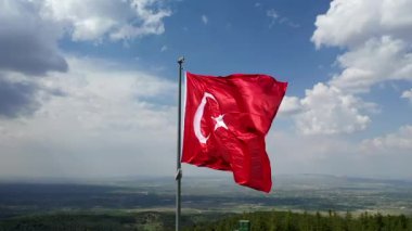 Türk Bayrağı sallıyor. Bulutlu bir günde Türk Bayrağı 'nın insansız hava aracıyla yüksek kaliteli görüntüsü. Yüksek kaliteli FullHD görüntüler