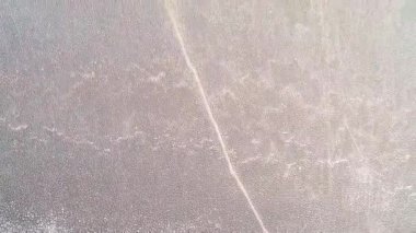 Kurumuş ve çatlamış toprak, suyu çekilen gölün kurumuş toprağı, çatlamış kum dokusu, drone ile havadan çekilen. Yüksek kalite 4k görüntü