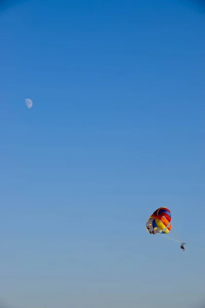 Lidé Parasailing Modré Obloze Vlečen Lodí Multicloured Parasail Měsíc Obloze — Stock fotografie