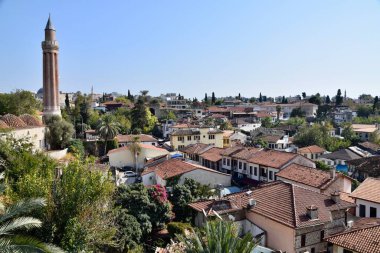 Antalya, Türkiye, Şehir Merkezi sokak manzarası. Yeni binaları olan eski bir bina. Alışveriş kafeleri. Hortum çatıları. Cami Minaresi.
