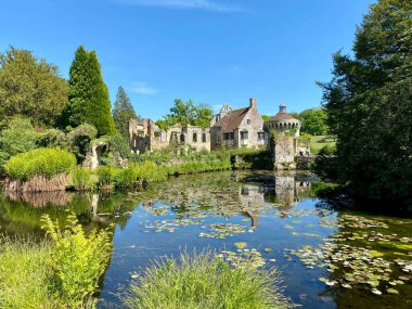 Scotney Castle, Kent, İngiltere. Hendeğe yansıyan ev, mavi gökyüzü. 