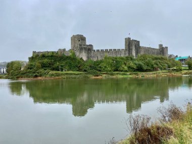Pembroke Castle reflected in the river with grey sky. Pembroke, Wales, September 19, 2021. 