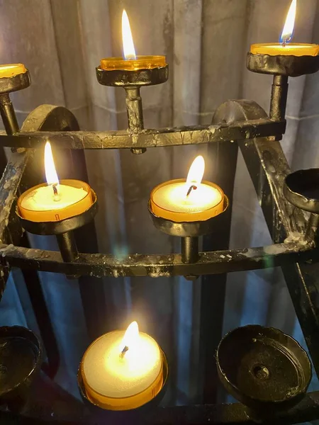 Church candles in St Davids Cathedral. Candles on metal frame.