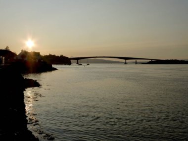 Skye Bridge , Scotland, at Sunset from Kyleakin. Silhouette with calm sea. 