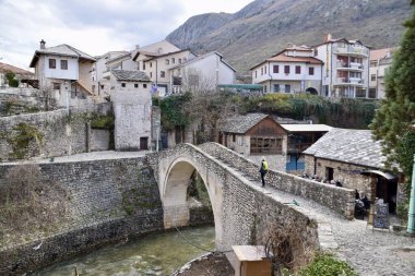 Mostar, Bosnia and Herzegovina, March 2020. Stone bridge over stream. Street Scene. 