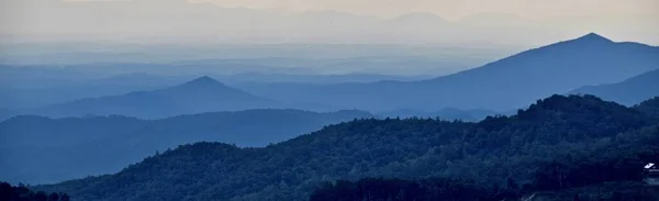 Blue Ridge Mountains, North Carolina, USA. Blue mountains panorama, mist in the distance, trees in the foreground.