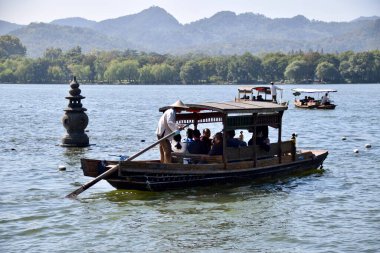 Batı Gölü 'ndeki Yüzen Taş Pagoda' nın yanındaki turist botu. Hangzhou, Zhejiang, Çin. 28 Ekim 2018. 