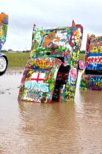 Cadillac Ranch in the rain, with the cars reflected in the water. Amarillo, TX, USA. June 8. 2014. 