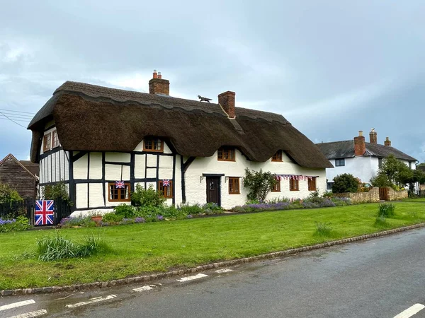 Traditional English thatched cottage with black exposed woodwork. Warwickshire, England, UK.