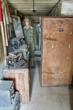 2. Dünya Savaşı 'ndan kalma Alman sığınağının içinde Le Roosevelt Bar' ın yanında askeri teçhizat ve Solider Model ile. Utah Plajı, Fransa, 3 Temmuz 2023. 