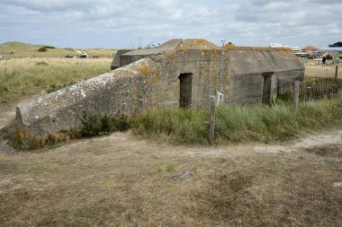 Utah sahilinin hemen dışında, mavi bulutlu gökyüzünün altında, 2. Dünya Savaşı 'ndan kalma Alman Beton Sığınağı. Utah Plajı, Fransa, 3 Temmuz 2023. 