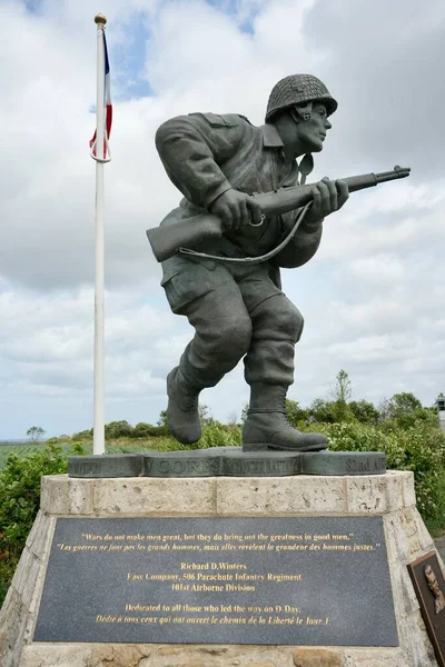 stock image Monument to Major Richard D Winters and Easy Company, with US and French flags and countryside behind. Utah Beach, France, July 3, 2023. 